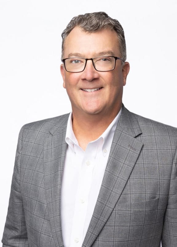 a man in a suit and glasses smiling