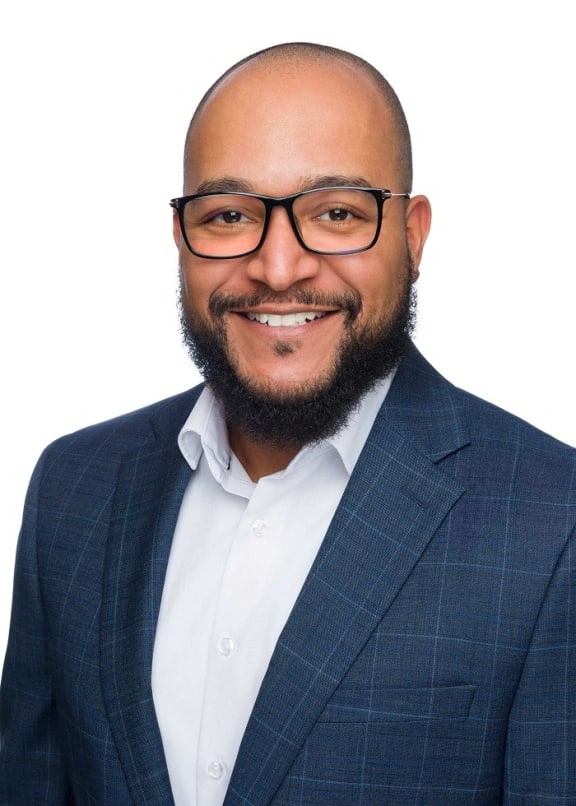 a man in a suit and glasses smiling