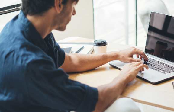 A man typing on laptop 