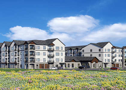 A large, modern apartment building with a grassy field in front.