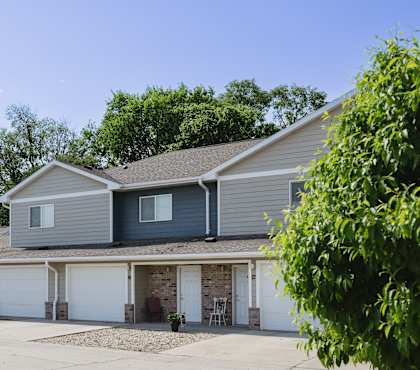 A row of houses with a gravel driveway in front.