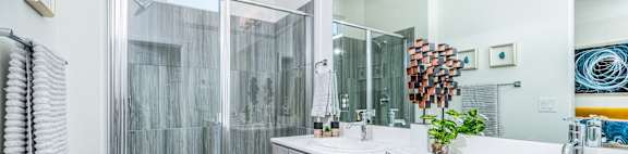 a bathroom with white cabinets and a walk in shower