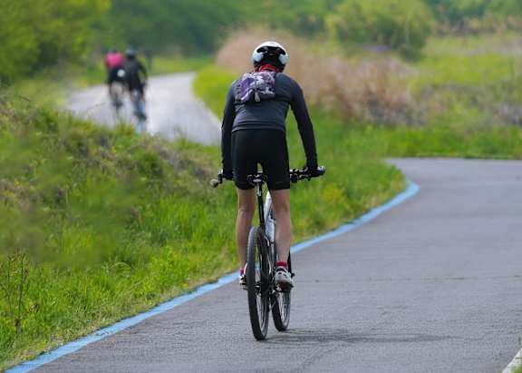 A person is riding a bicycle on a paved path.