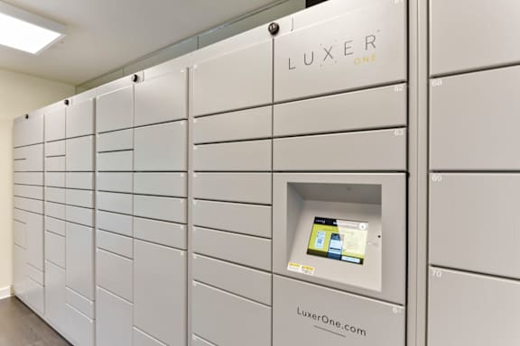 A row of white lockers with the word LUXER ONE printed on the top.