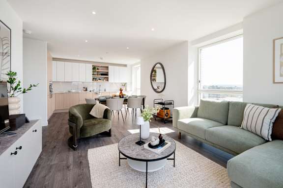 A modern living room with a green couch and a coffee table.