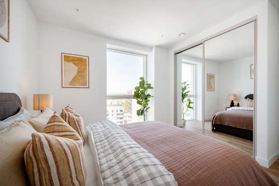 A bedroom with a large bed and a view of the city.
