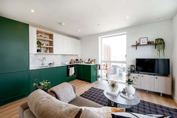 A living room with a grey couch and a green cabinet.