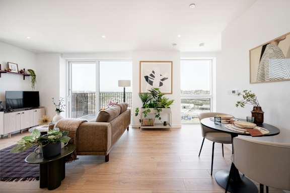 A living room with a couch, a table, and a television.