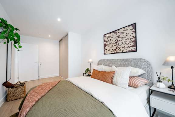 A bedroom with a large bed and a painting on the wall.