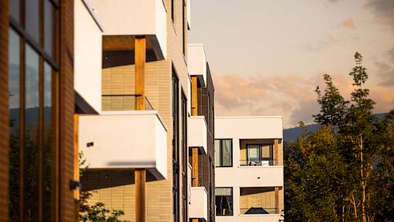 A modern building with a glass facade and wooden accents.