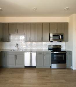 A kitchen with a wooden ceiling and a white counter.