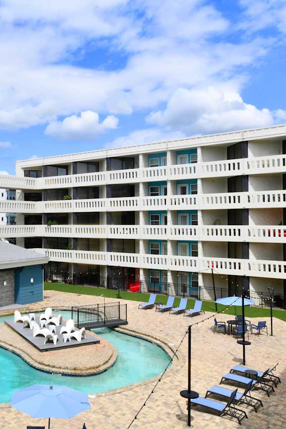 A large apartment complex with a pool and hot tub.