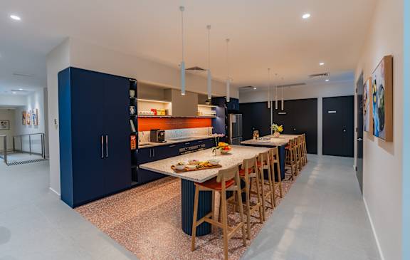 a large kitchen with a long island and a long table with chairs