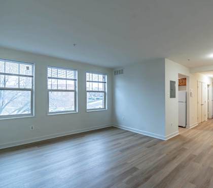 an empty living room with white walls and wood floors
