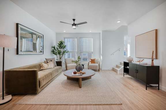 A living room with a brown sofa, a coffee table, and a painting on the wall.