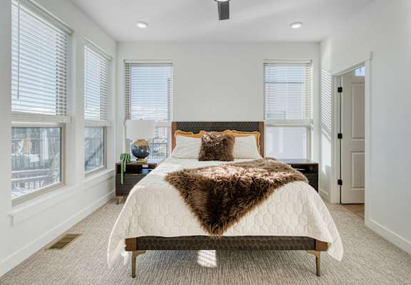 A bedroom with a large bed and a view of the city.