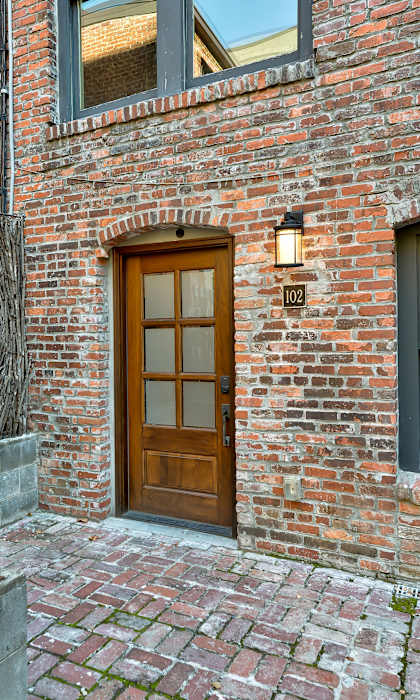 A brick building with a wooden door and a window.