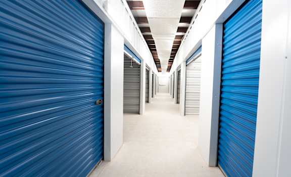 A long hallway with blue doors on both sides.
