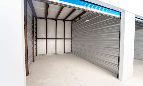 A storage unit with a closed grey shutter door.