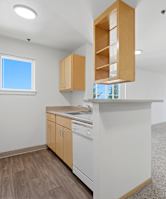 A kitchen with white appliances and wooden cabinets.