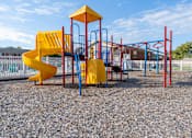 Thumbnail 5 of 6 - A playground with a yellow slide and red and blue structures.