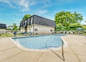 Thumbnail 6 of 6 - A swimming pool in a backyard with a building in the background.