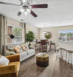 A living room with a white couch, a wooden coffee table, and a flat-screen TV.