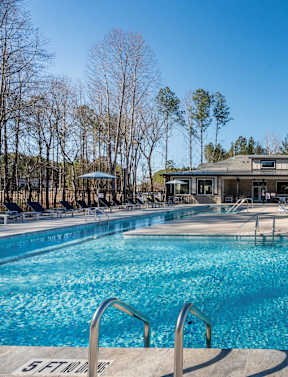 A large swimming pool with a building in the background.