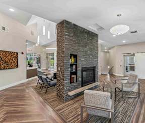 A modern living room with a stone fireplace and wooden floors.