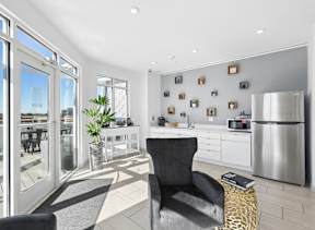 Rooftop community kitchen with refrigerator, microwave, counter space, and terrace access at The Constellation on King