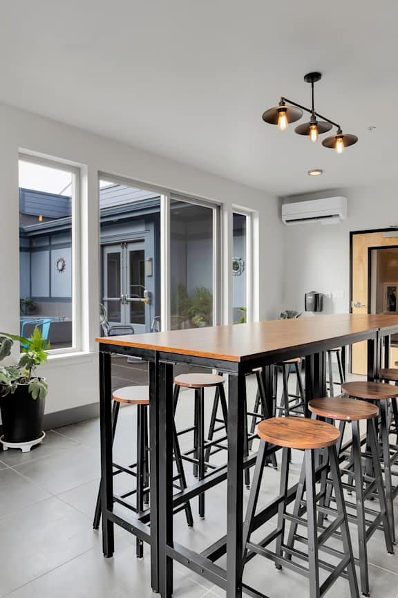 A modern kitchen with a bar area and a television mounted on the wall.