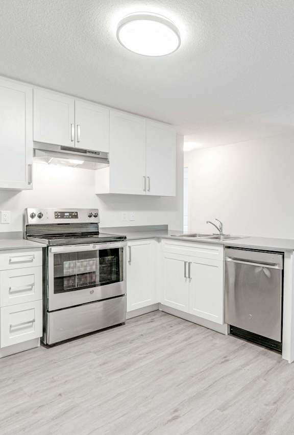 A modern kitchen with stainless steel appliances and white cabinets.