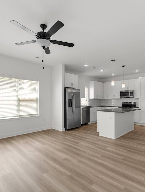 A modern kitchen with white cabinets and stainless steel appliances.