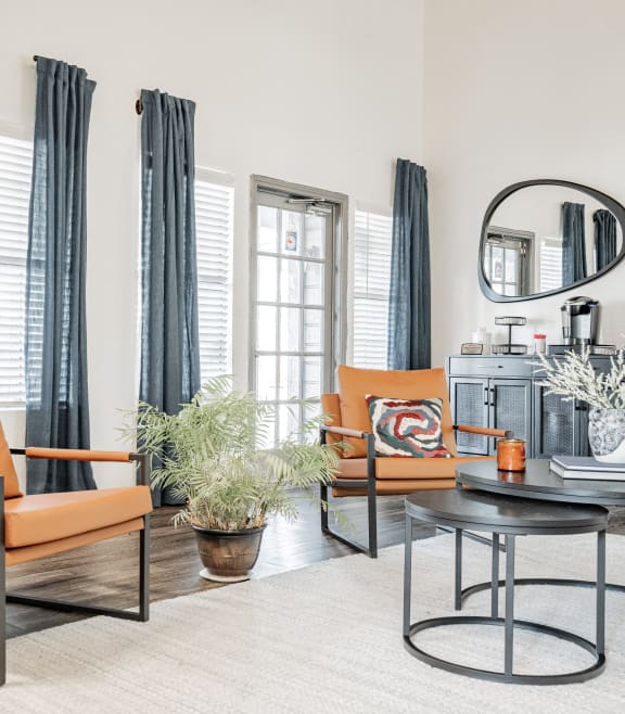 a living room with orange chairs and a coffee table