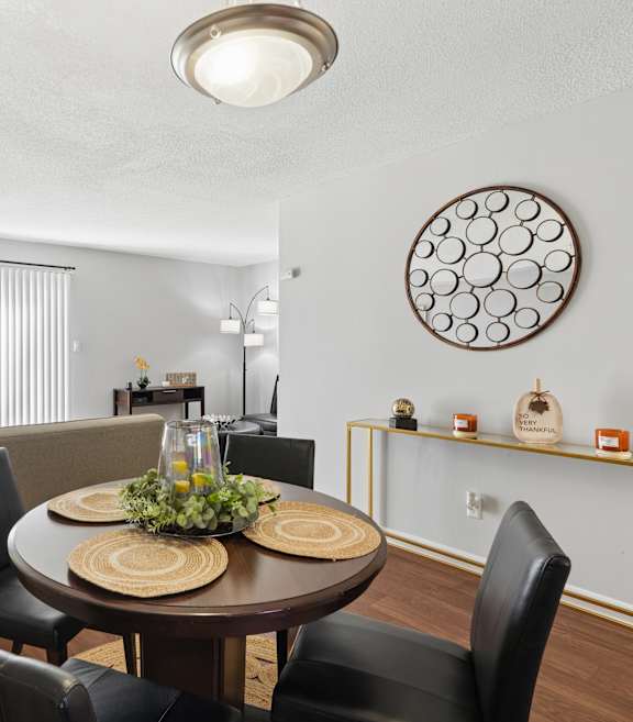 A dining room with a round table and chairs.