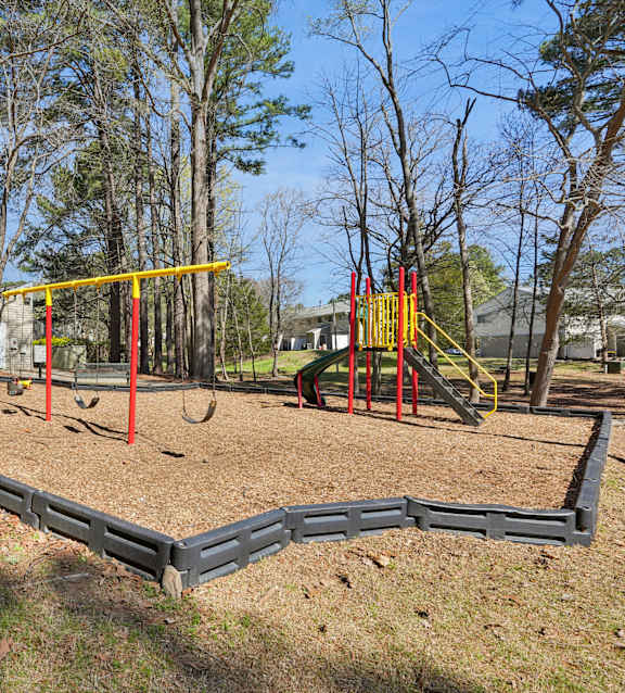 A playground with a swing set and a slide.