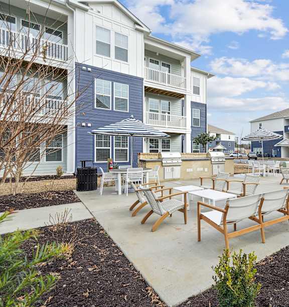 a covered patio with couches and chairs and a tv