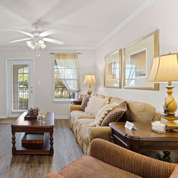 an open concept living room and dining area with a white dining table and rattan chairs