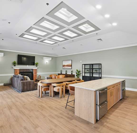 A well-lit, spacious kitchen and dining area with wooden floors and furniture.