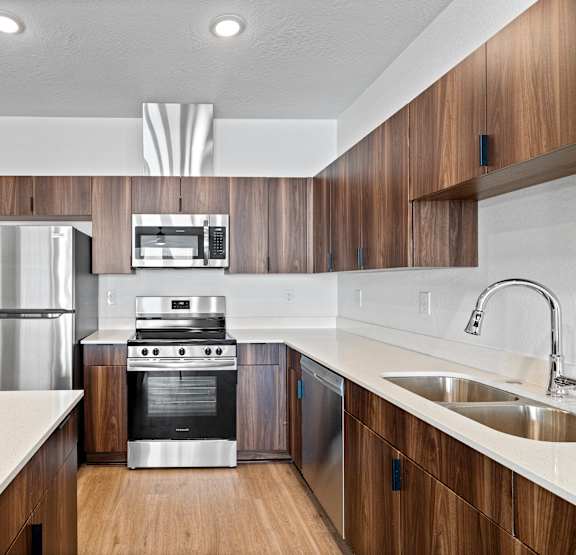 a kitchen with wood floors and wooden cabinets