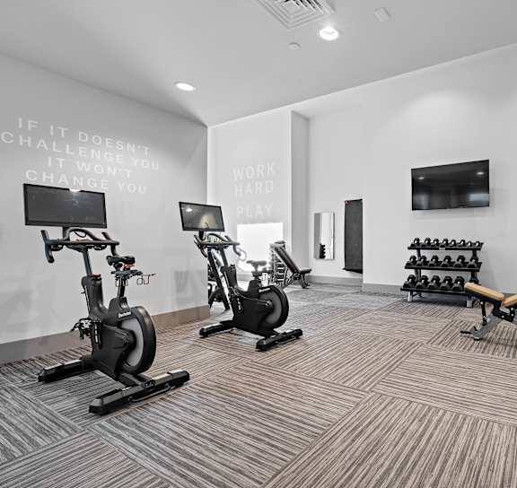 two treadmills and exercise balls in the gym of a building