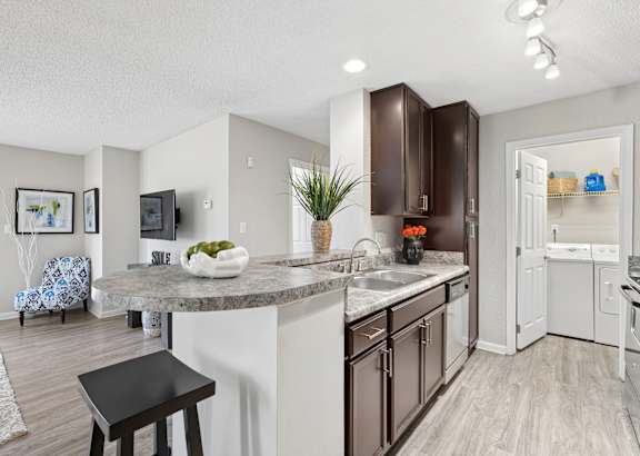 A kitchen with a white counter top and brown cabinets.