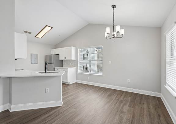 A kitchen with a white island and wooden floors.
