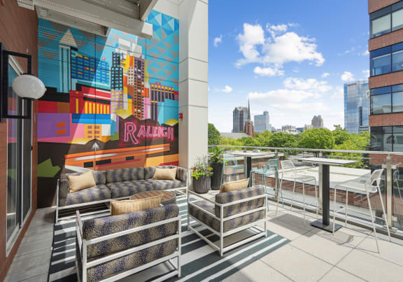 a terrace with couches and a table and a mural on the wall