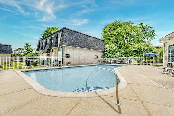 A swimming pool in a backyard with a building in the background.