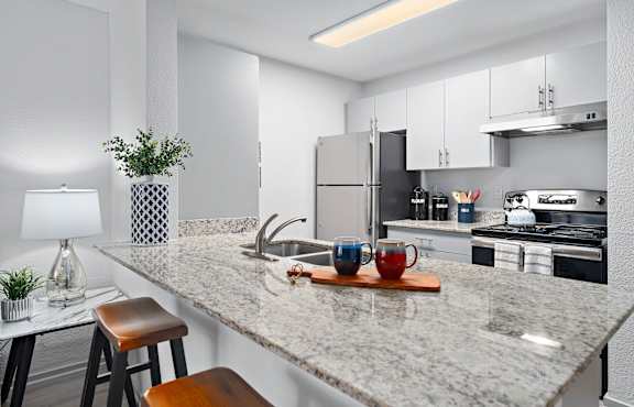 A kitchen with a marble countertop and a stool.