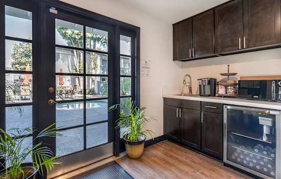 A modern kitchen with dark wood cabinets and a glass door.