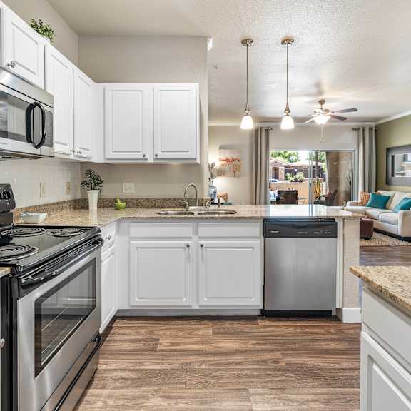 A kitchen with white cabinets and a granite countertop.