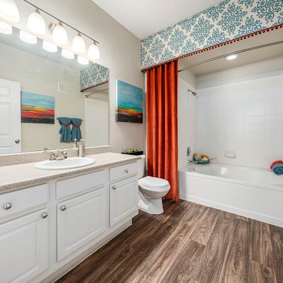 A bathroom with a white toilet, sink, and bathtub.