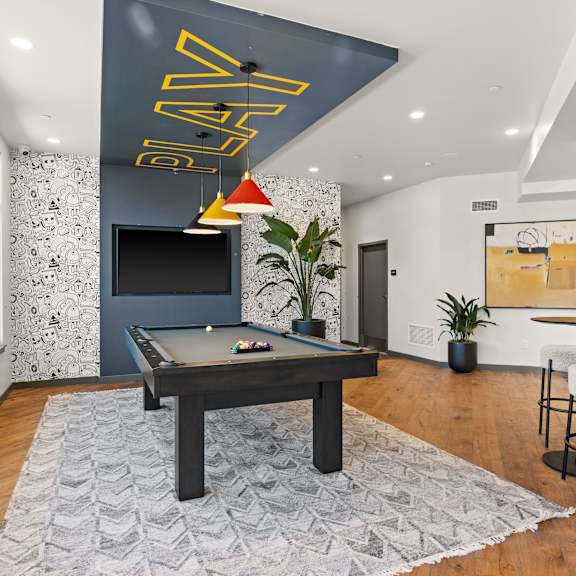 a game room with a pool table and a tv